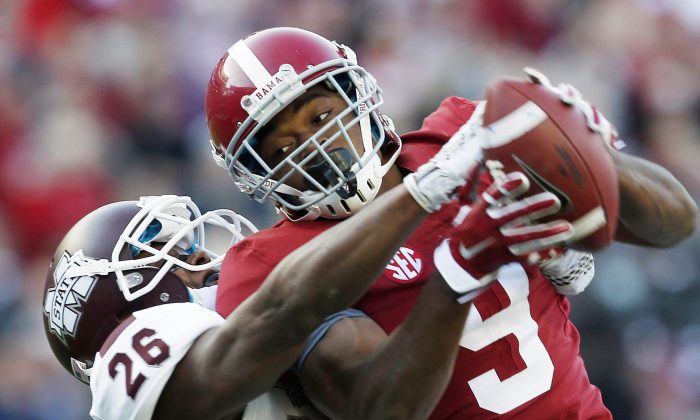 Alabama wide receiver Amari Cooper (9) catches a 50-yard pass against Mississippi State defensive back Kendrick Market (26) in the first half of an NCAA college football game on Saturday, Nov. 15, 2014, in Tuscaloosa, Ala. (AP Photo/Butch Dill)