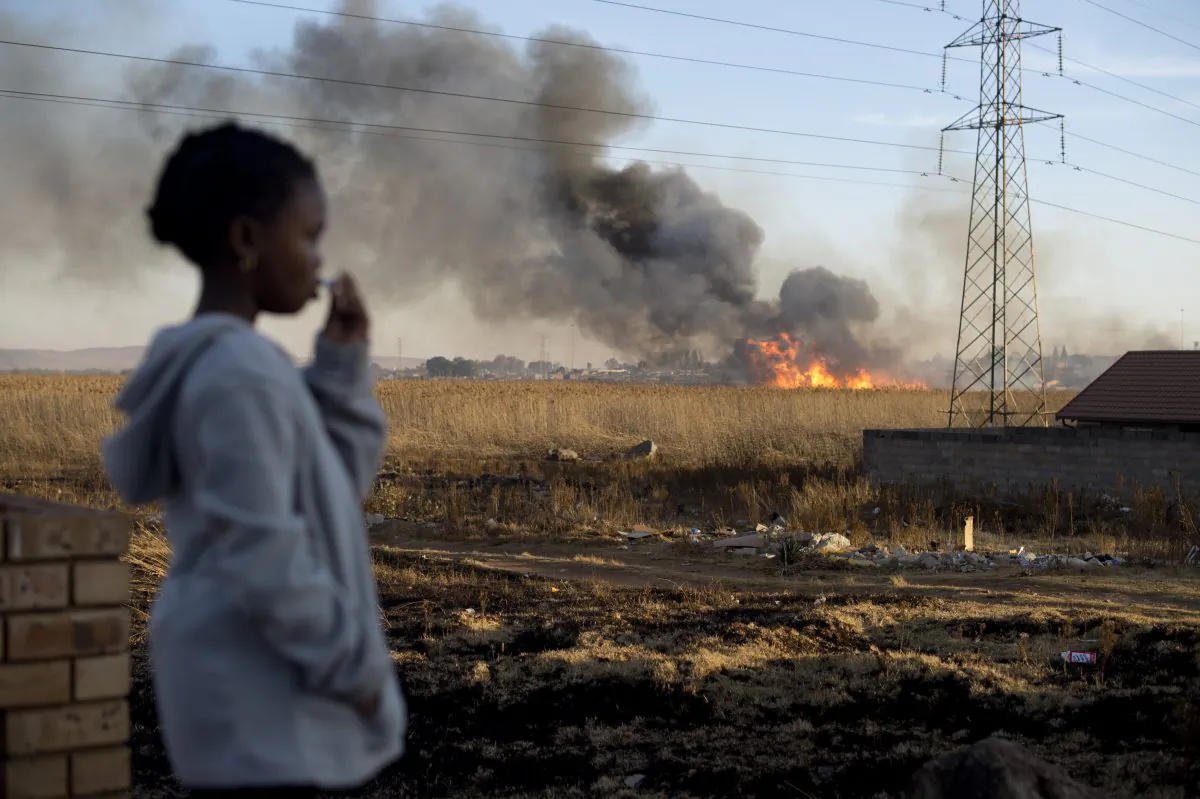 A girl looks at a fire in the township of Soweto on June 27, 2013. (Odd Andersen/AFP/Getty Images)