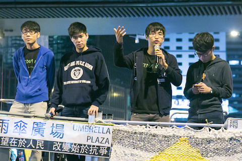 Alex Chow, secretary-general of the Hong Kong Federation of Students, along with other members, speak to large crowd of people who came to hear the students leaders talk after being denied entry into Beijing in the Central District of Hong Kong on Nov. 15, 2014. (Benjamin Chasteen/Epoch Times)