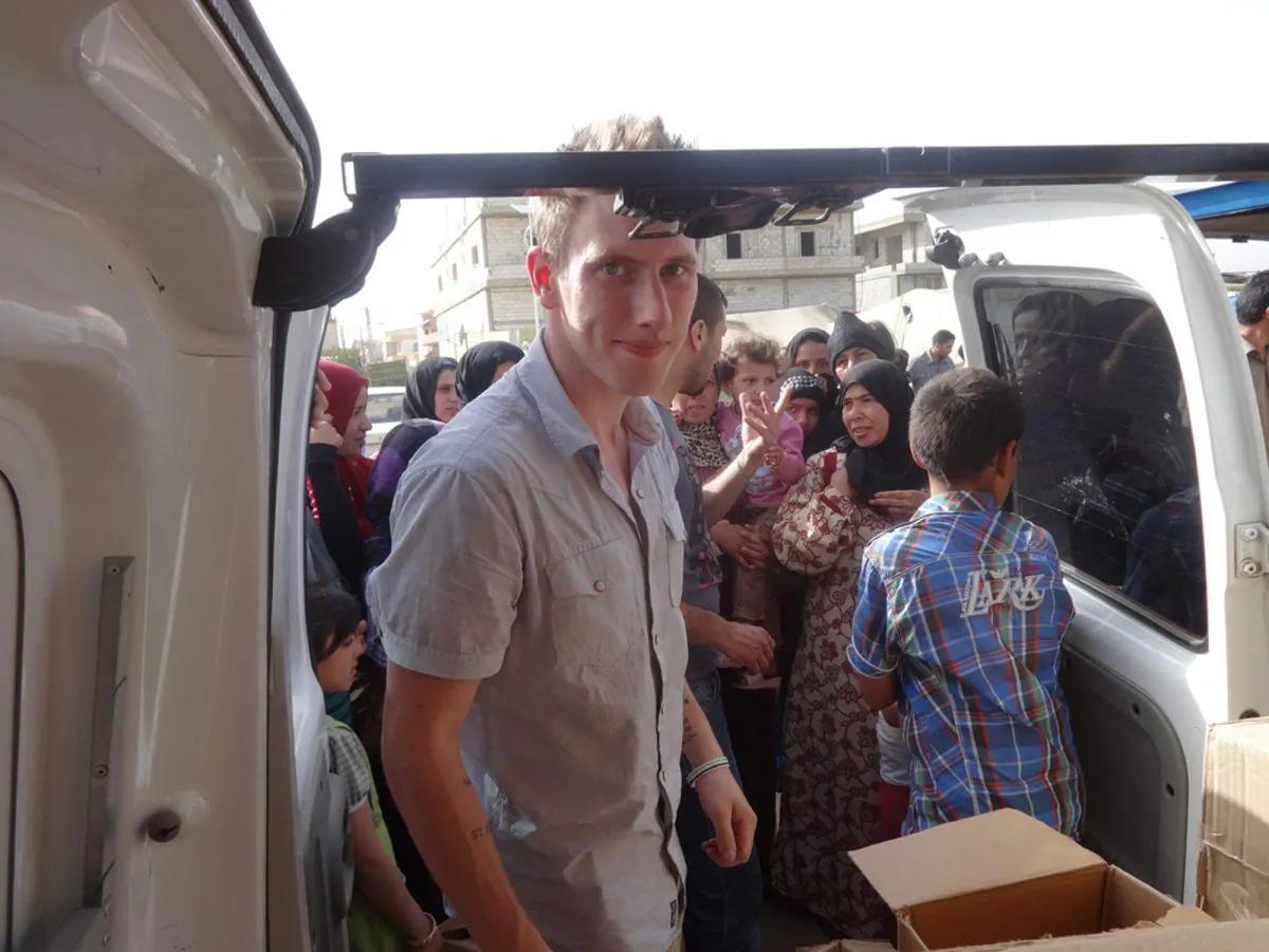 Peter Kassig delivering supplies for Syrian refugees. A new graphic video purportedly produced by Islamic State militants in Syria released on Sunday, Nov. 16, 2014, claims US aid worker Kassig was beheaded. (AP Photo/Courtesy of Kassig Family)
