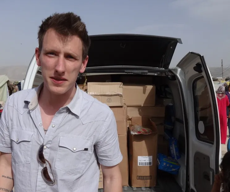 Peter Kassig stands in front of a truck filled with supplies for Syrian refugees in this undated photo provided by his family. A new graphic video purportedly produced by Islamic State militants in Syria released Sunday, Nov. 16, 2014 claims U.S. aid worker Kassig was beheaded. (AP Photo/Courtesy Kassig Family)