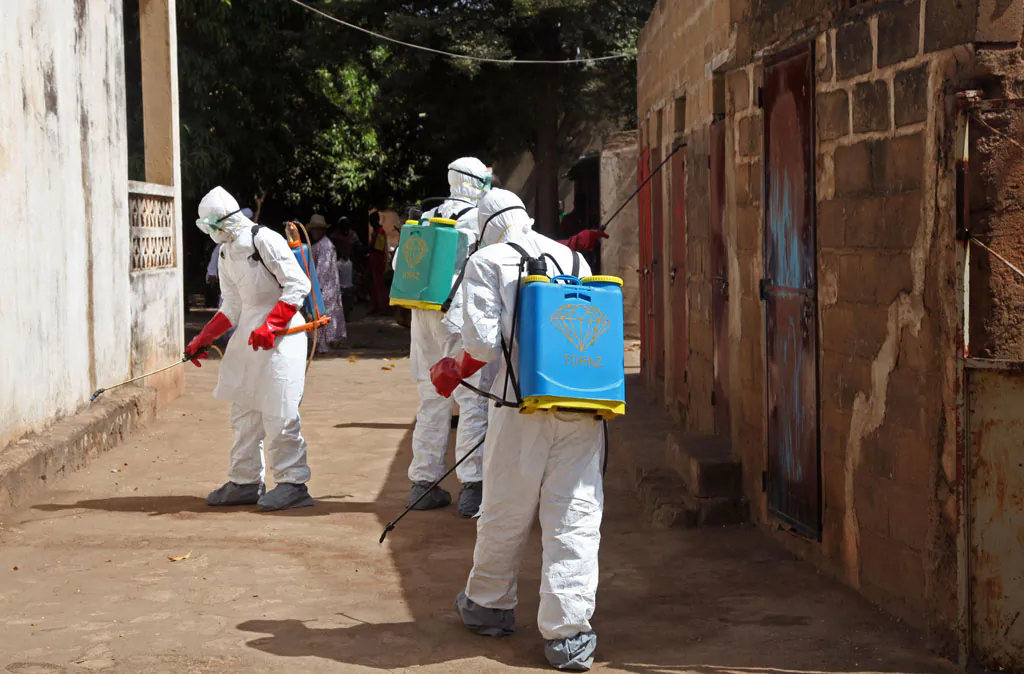 Health workers spray disinfectant around a mosque after the body of a man suspected of dying from the Ebola virus was washed inside before being berried in Bamako, Mali, on Nov. 14, 2014. It all started with a sick nurse, whose positive test results for Ebola came only after death. In a busy clinic that treats Bamako’s elite as well as wounded UN peacekeepers, who was the patient who had transmitted the virus? Soon hospital officials were taking a second look at the case of a 70-year-old man brought to the capital late at night from Guinea suffering from kidney failure. On Friday, Malian health authorities went to disinfect the mosque where the 70-year-old’s body was prepared for burial - nearly three weeks ago. Already some are criticizing the government for being too slow to react when health authorities had announced his death as a suspected Ebola case earlier in the week. (AP Photo/Baba Ahmed)