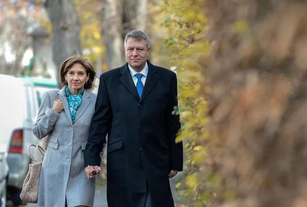 Klaus Iohannis, leader of Romania's center-right Liberals and mayor of the Transylvanian city of Sibiu, holds his wife Carmen's hand while walking to a polling station in Sibiu, in the central Romanian Transylvania region, Sunday, Nov. 16, 2014. Romanians have begun voting in a presidential runoff between the prime minister who promises stability and a city mayor who says he will fight corruption. The winner will replace President Traian Basescu, who steps down after 10 years. (AP Photo/Andreea Alexandru, Mediafax)