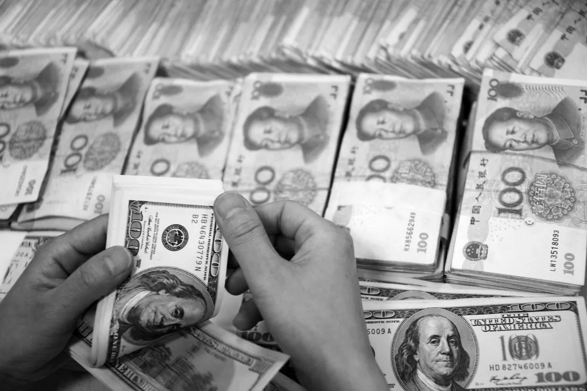 U.S. dollar notes are counted next to stacks of Chinese 100 yuan (RMB) bank notes at a bank in Huaibei, in eastern China's Anhui Province, on Sept. 23, 2014. (STR/AFP/Getty Images)
