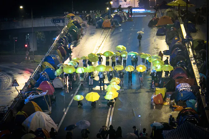 Pro-democracy protesters hold yellow umbrellas as they stand in a pattern forming a large umbrella in the Central District in Hong Kong on Nov. 8, 2014. (Benjamin Chasteen/Epoch Times)