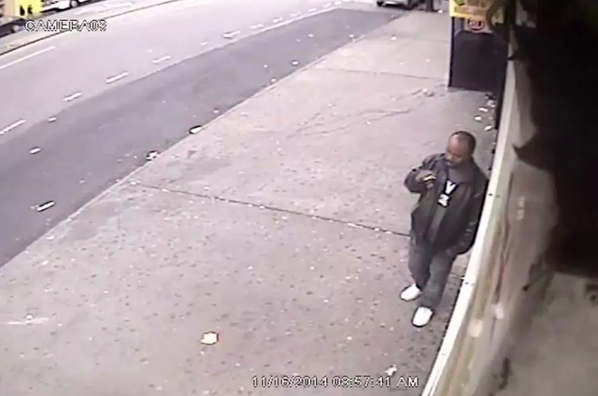In this surveillance video a man smokes a cigarette outside a convenience store in the Bronx borough of New York on Sunday, Nov. 16, 2014. The NYPD says the man is suspected of shoving a stranger off a subway platform Sunday in front of an oncoming subway train. (AP Photo/New York Police Department)