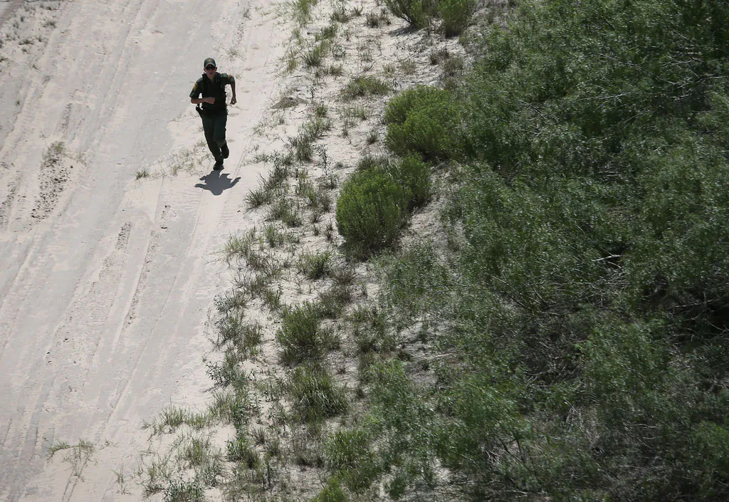 A US Border Patrol agent chases down undocumented immigrants on Sept. 11, 2014, near Falfurrias, Texas. Agents from US Customs and Border Protection patrol the area day and night in search of smugglers bringing both illegal immigrants and drugs into the U.S. (John Moore/Getty Images)