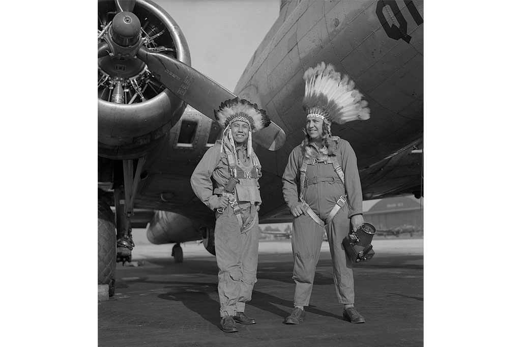 Gus Palmer (Kiowa, L), side gunner, and Horace Poolaw (Kiowa), aerial photographer, in front of a B-17 Flying Fortress. MacDill Field, Tampa, Fla., ca. 1944. (Estate of Horace Poolaw)