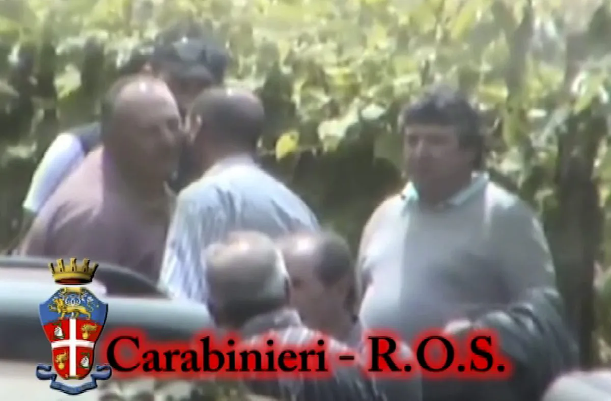 In this photo taken from a video provided by the Italian Carabinieri (paramilitary police), people identified by police as Italian cryme sindicate 'ndrangheta' members kiss each other. Police in northern Italy say for the first time they have video of a secret, ritual swearing-in ceremony for the 'ndrangheta', a powerful Italian crime syndicate. Their investigation also led to 40 arrests in a crackdown of extortion by mobsters preying on businesses in Lombardy and across the border in Switzerland. Milan Prosecutor Ilda Boccassini told reporters Tuesday the video of the ritual ceremony for recruits shows how the strength of the 'ndrangheta' is the force of tradition." (AP Photo/Carabinieri)