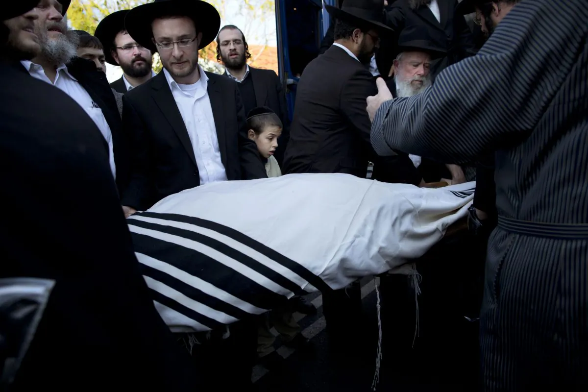 Orthodox Jews carry the body of Mosheh Twersky during his funeral in Jerusalem, Tuesday, Nov. 18, 2014. Two Palestinian cousins armed with meat cleavers and a gun stormed a Jerusalem synagogue during morning prayers Tuesday, killing Twersky and three other people in the city's bloodiest attack in years. Police killed the attackers in a shootout. (AP Photo/Oded Balilty)