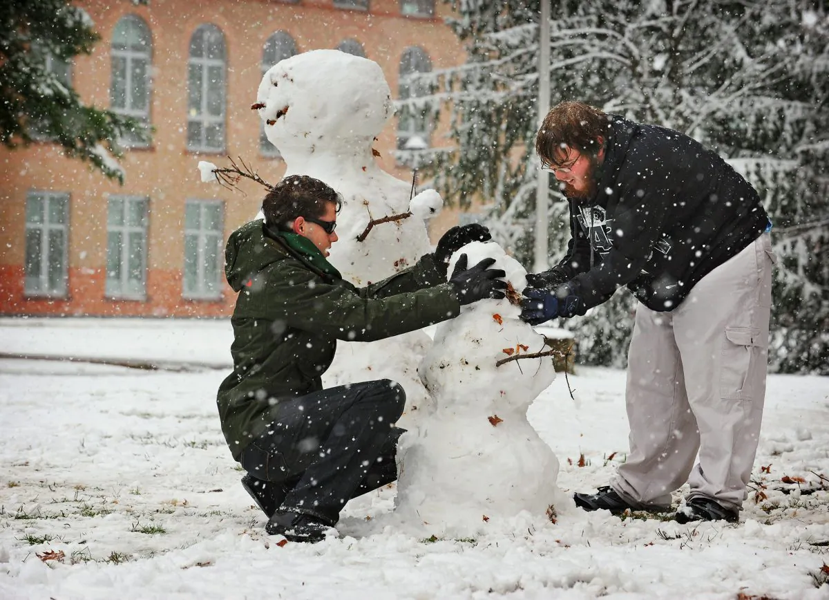 Clarkson University students, sophomore David B. Josephs, left, of Potsdam and freshman Dallas J. Blowers, of Watertown build a snowman at Clarkson University in Potsdam, N.Y., Monday, Nov. 17, 2014. More than a month before the arrival of winter, forecasters said snow off the Great Lakes could fall through Wednesday afternoon at a rate of five inches per hour in spots, and that wind gusts of up to 45 mph had the potential to make travel nearly impossible along sections of the New York State Thruway and Interstate 81. (AP Photo/ Watertown Daily Times, Jason Hunter) MANDATORY CREDIT