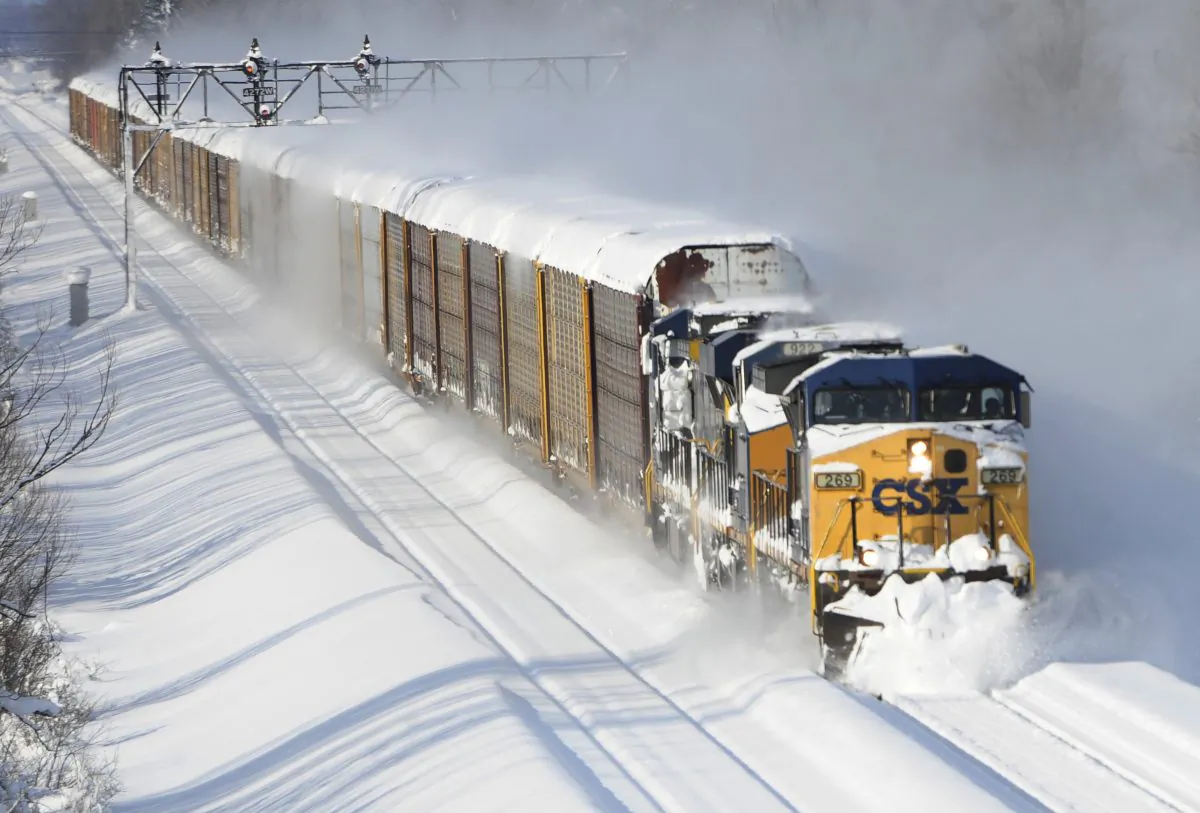 A CSX freight train plows its way past the Cemetery Rd. overpass in Lancaster, N.Y., on Wednesday, Nov. 19, 2014. A lake-effect snow storm dumped over five feet of snow in areas across Western New York. Another two to three feet of snow is expected in the area, bringing snow totals to over 100 inches, almost a years' worth of snow in three days. (AP Photo/Gary Wiepert)