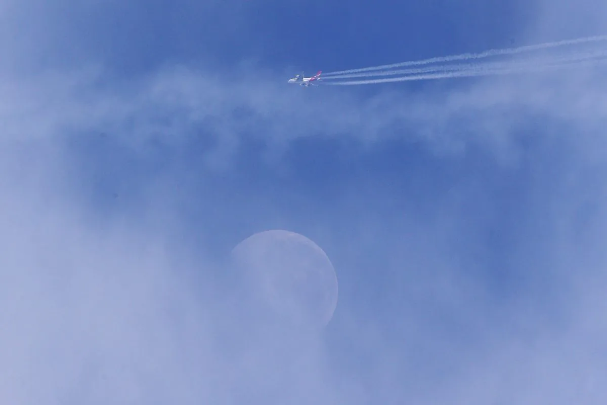 A Qantas airplane flies over the moon during a Collingwood Magpies AFL Fitness Camp on Nov. 14, 2014, in Falls Creek, Australia. (Michael Dodge/Getty Images)