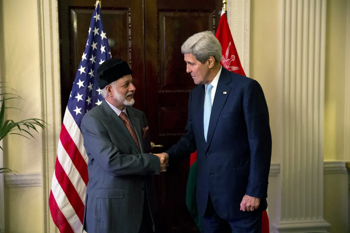 U.S. Secretary of State John Kerry, right, and Oman Foreign Minister Yusuf Bin Alawi bin Abdullah perform a posed handshake for photographers at the start of their meeting at the official residence of the U.S. ambassador to Britain, Winfield House, in London, Tuesday, Nov. 18, 2014.  (AP Photo/Matt Dunham)