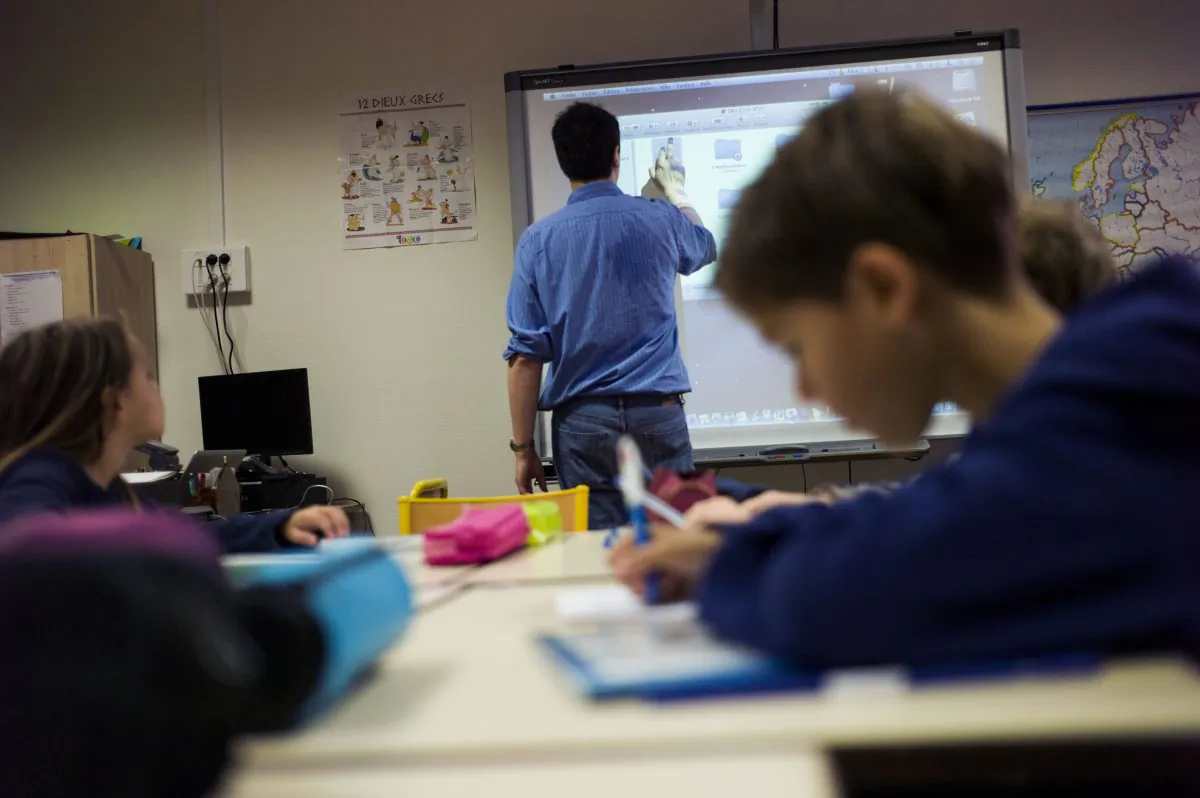 A teacher uses a touchpad board during his lesson at an elementary school on September 9, 2014 in Paris. (Fred Dufour/AFP/Getty Images)
