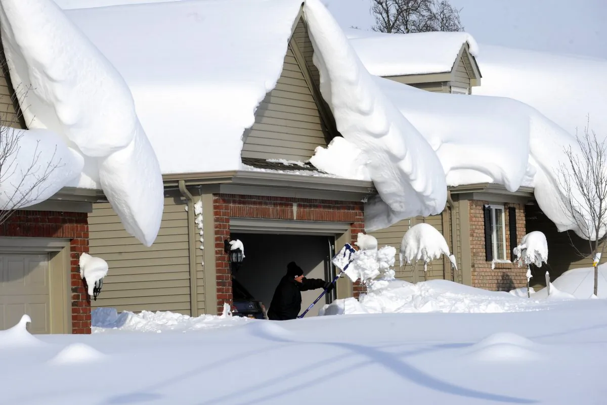 Snowdrifts create a beautiful setting as a man tries to dig out his driveway on Bowen Road in Lancaster, N.Y., on Wednesday, Nov. 19, 2014. (AP photo/Gary Wiepert)
