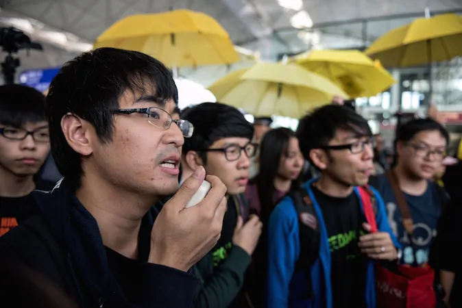 Hong Kong democracy protest leader Alex Chow (2nd L) talks to the media before he and two other activists had tried to board a flight to Beijing, at Hong Kong's international airport on November 15, 2014. Three Hong Kong pro-democracy protest leaders were unable to leave the city for a planned trip to Beijing in hopes of bringing their demands for political reform to Chinese authorities. (Alex Ogle/AFP/Getty Images)