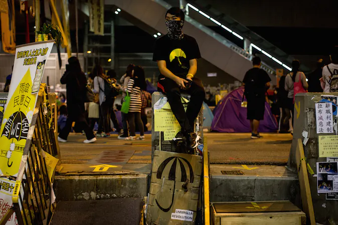 A pro-democracy activists sits between a set of makeshift stairs on the street outside Hong Kong's Government complex on November 16, 2014 in Hong Kong. (Chris McGrath/Getty Images)