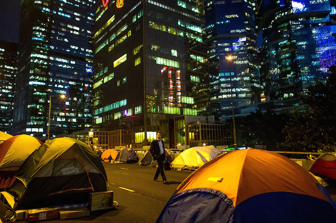 A business man walks through rows of tents setup by pro-democracy activists on the road outside Hong Kong's Government complex on November 20, 2014 in Hong Kong. (Chris McGrath/Getty Images)