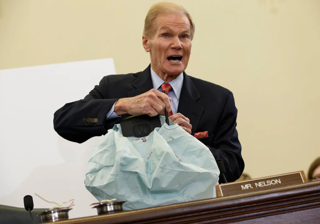 Senate Commerce Committee member Sen. Bill Nelson (D-Fla.) displays the parts and function of a defective airbag made by Japan's Takata Corp. that has been linked to multiple deaths and injuries in cars driven in the U.S., during the committee's hearing on Capitol Hill in Washington, D.C., on Nov. 20, 2014. (AP Photo/J. Scott Applewhite)