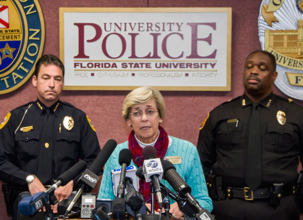 Mary Coburn (C), vice president of student affairs, talks to the media during a news conference about a shooting at the Strozier Library on the Florida State University campus, Thursday, Nov. 20, 2014, in Tallahassee, Fla. Three students were wounded and the gunman was shot and killed by police officers. Tallahassee police Chief Michael Deleo (L) and FSU police Chief David Perry stand in the background. (AP Photo/Mark Wallheiser)