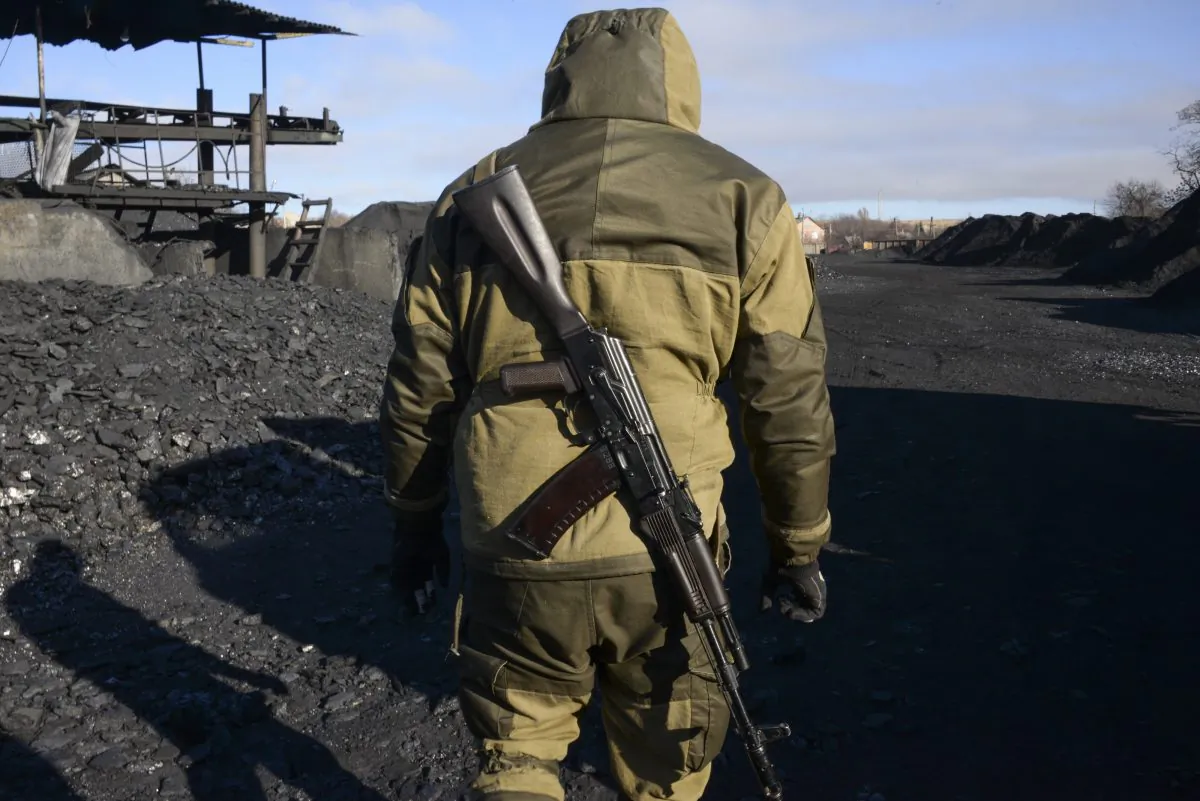A pro-Russia rebel patrols an illegal coal mining warehouse in Torez, eastern Ukraine, on Nov. 20, 2014. As battle raged in rebellion-wracked eastern Ukraine, cargo trains piled high with coal thundered along rail tracks to keep heating and power going to households in rebel-held territory. Coal is the lifeblood of this region dominated by pro-Russian separatists—and now the source of its first corruption scandal. (AP Photo/Mstyslav Chernov)
