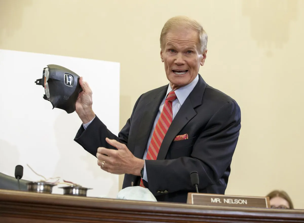 Senate Commerce Committee member Sen. Bill Nelson (D-Fla.) displays the parts and function of a defective airbag made by Takata of Japan that has been linked to multiple deaths and injuries in cars driven in the US, Thursday, Nov. 20, 2014, during the committee's hearing on Capitol Hill in Washington. (AP Photo/J. Scott Applewhite)