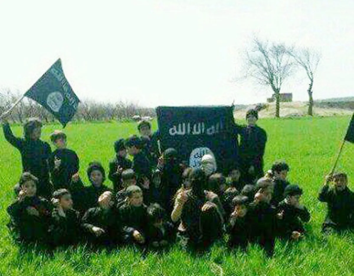 This undated image posted online and made available on Thursday, Nov. 20, 2014 by Raqqa Is Being Slaughtered Silently, an anti-Islamic State group organization, shows children at an Islamic State group training camp in Raqqa, Syria. The image has been verified and is consistent with other AP reporting. Across the vast region in Syria and Iraq that is part of the Islamic State group's self-declared caliphate, children are being inculcated with the extremist group's radical and violent interpretation of Shariah law. (AP Photo/Raqqa Is Being Slaughtered Silently)