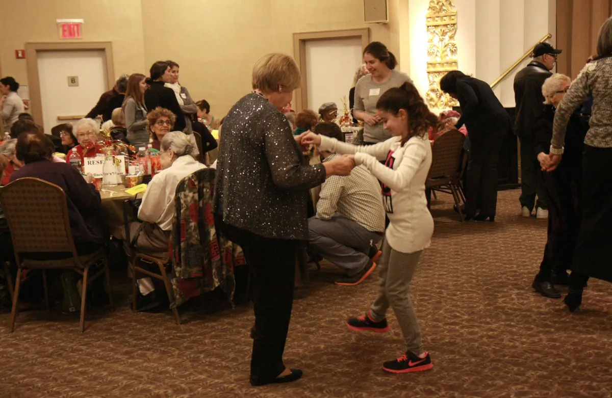 People dance at DOROT's annual Thanksgiving banquet for seniors at the Congregation Rodeph Shalom on the Upper West Side in Manhattan, N.Y., on Nov. 23, 2014. (Catherine Yang/Epoch Times)