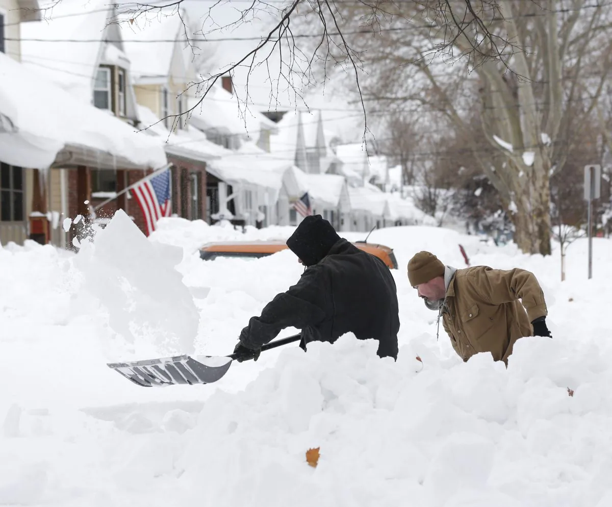 Mark Petrik and Dennis Smith dig out their south Buffalo driveway on Saturday, Nov. 22, 2014, in Buffalo, N.Y. (AP Photo/Mike Groll)