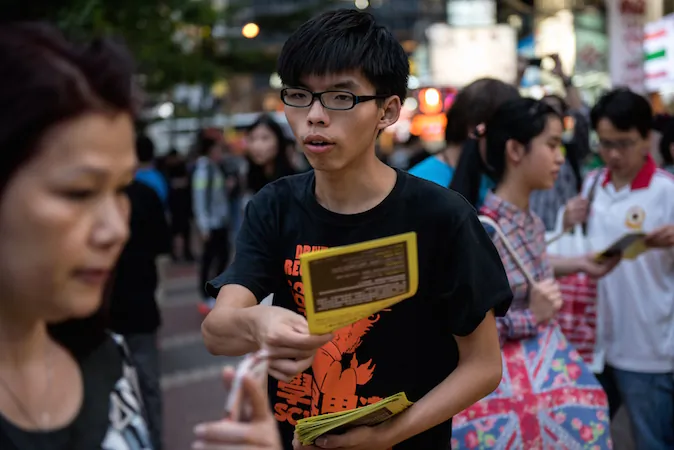 Student leader Joshua Wong (C) hands out flyers in support of the Hong Kong pro-democracy protests in the Causeway Bay area of Hong Kong on November 16, 2014. (Alex Ogle/AFP/Getty Images)