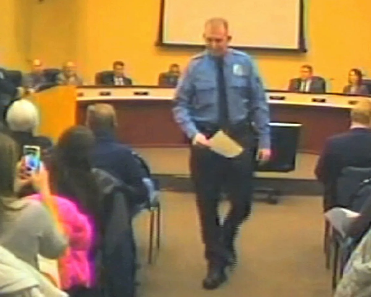 In this file Feb. 11, 2014 image from video released by the City of Ferguson, Mo., is officer Darren Wilson at a city council meeting in Ferguson. (AP Photo/City of Ferguson)