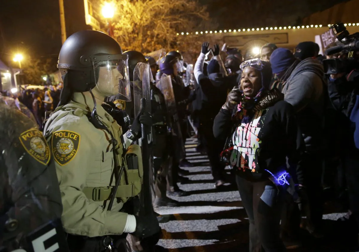 Police officers and protesters ready to react to the announcement of the grand jury decision not to indict police officer Darren Wilson in the fatal shooting of Michael Brown, an unarmed black 18-year-old, in Ferguson, Mo., on Nov. 24, 2014. (AP Photo/David Goldman)