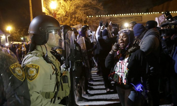 Police officers and protesters ready to react to the announcement of the grand jury decision not to indict police officer Darren Wilson in the fatal shooting of Michael Brown, an unarmed black 18-year-old, in Ferguson, Mo., on Nov. 24, 2014. (AP Photo/David Goldman)