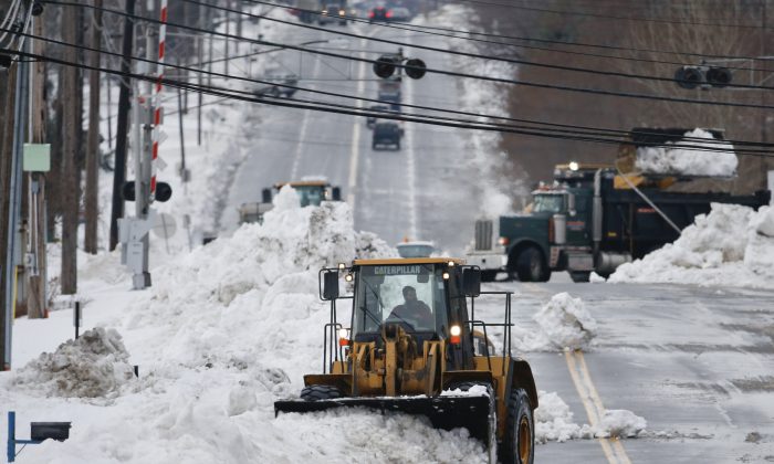 A front loader clears snow from Lake Avenue on Sunday, Nov. 23, 2014, in Orchard Park, N.Y. Western New York continues to dig out from the heavy snow dropped this week by lake-effect snowstorms. (AP Photo/Mike Groll)