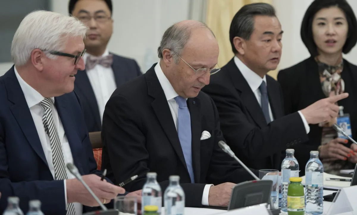 German Foreign Minister Frank-Walter Steinmeier, French Foreign Minister Laurent Fabius and Chinese Foreign Minister Wang Yi, from left, sit at the negotiation table during their talks on Iran, in Vienna, Austria, Monday, Nov. 24, 2014. (AP Photo/Joe Klamar)