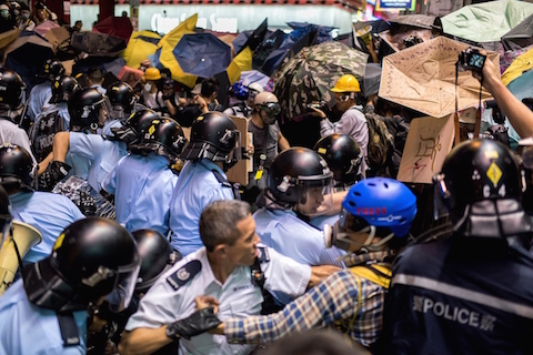 Police officers beat back pro-democracy protesters in the Mongkok district of Hong Kong on November 25, 2014. Hong Kong authorities tore down barricades at a protest site in Mongkok, the scene of some of the more violent clashes to take place during nearly two months of pro-democracy sit-ins. (Alex Ogle/AFP/Getty Images)
