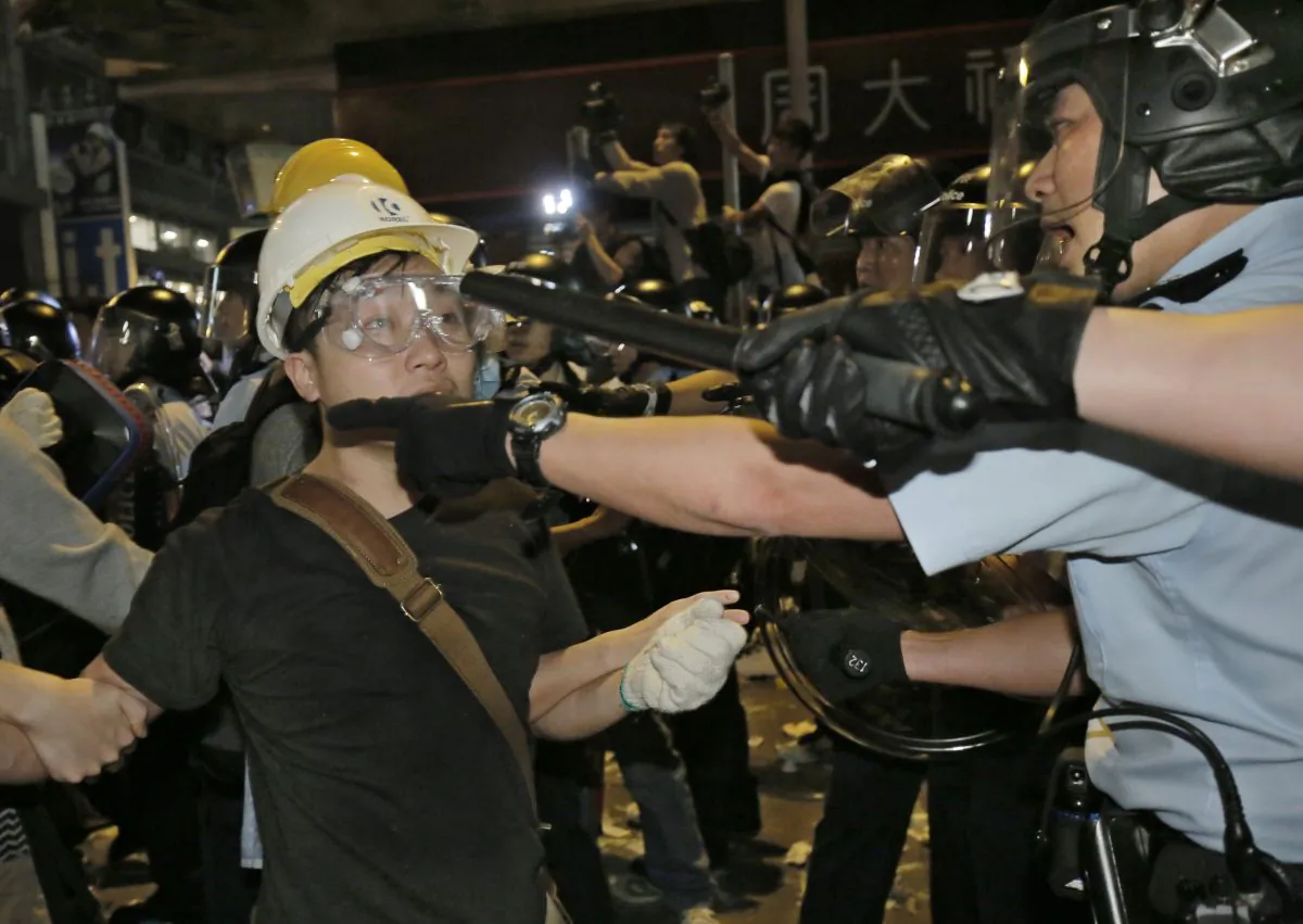 Police officers scuffle with protesters at an occupied area in Mong Kok district of Hong Kong early Wednesday, Nov. 26, 2014. An attempt by Hong Kong authorities to clear a 2-month-old pro-democracy protest camp in Mong Kok district spiraled into chaos Tuesday as hundreds more protesters flooded the crowded neighborhood, a flashpoint for earlier violent clashes with police and angry mobs. A total of 116 people were arrested, police said. (AP Photo/Vincent Yu)