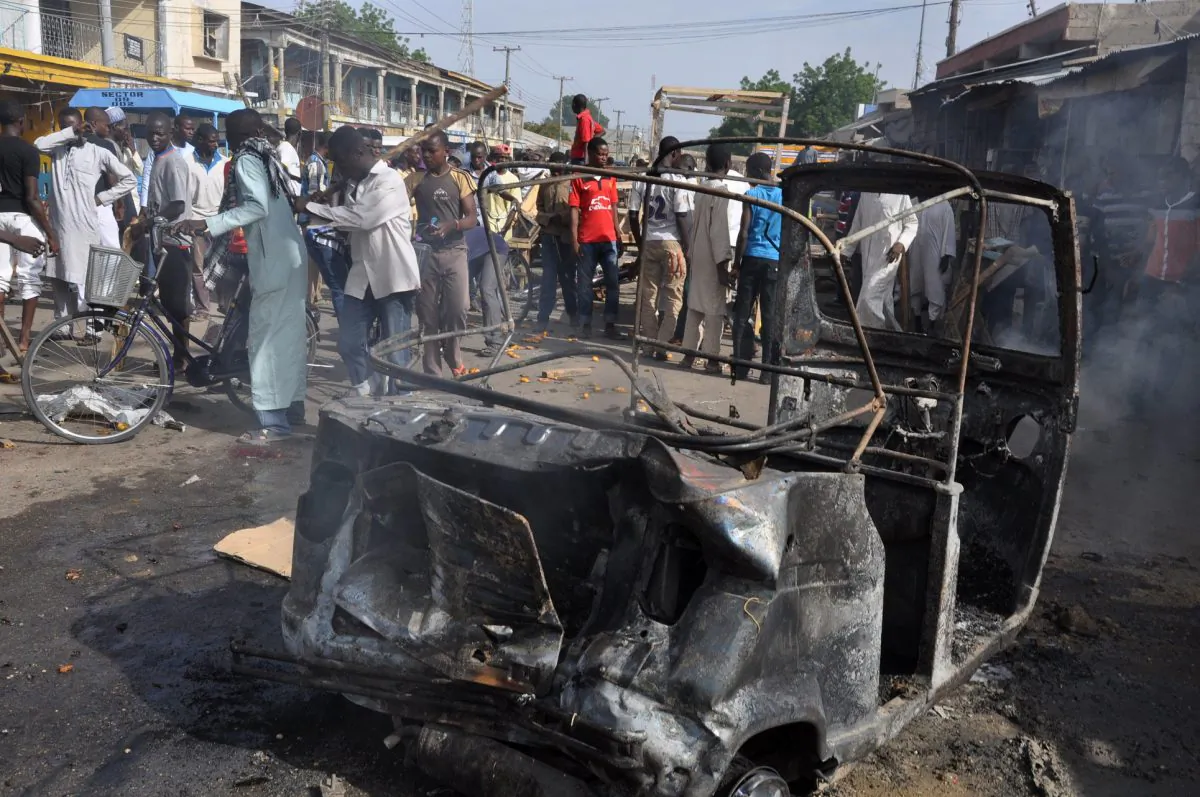 In this Tuesday, July, 2014 file photo, People gather at the scene of a car bomb explosion, at the central market, in Maiduguri, Nigeria. Today, Tuesday, Nov. 25, 2014. (AP Photo/Jossy Ola)