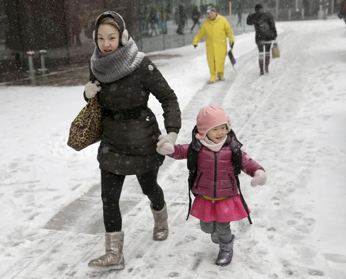 Pedestrians make their way through the snow in the Manhattan borough of New York on Tuesday, Jan. 21, 2014. New York's mayor Bill de Blasio announced that the city's schools will likely be closed on Tuesday amid reports of 2 to 3 feet of snow accumulation by late Tuesday, Jan. 27, 2015. (AP Photo/Seth Wenig)