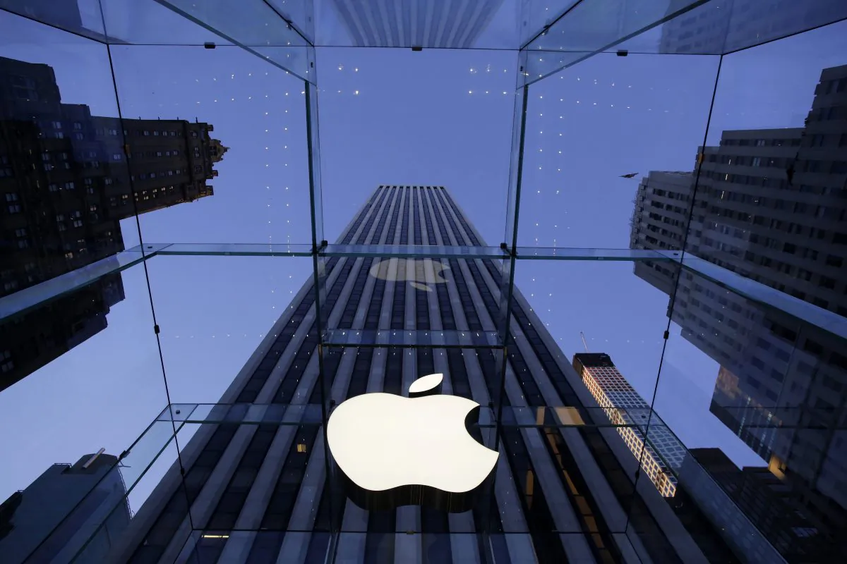 In this Sept. 5, 2014 file photo, the Apple logo hangs in the glass box entrance to the company's Fifth Avenue store, in New York. Apple, already the world's most valuable company, surpassed $700 billion in market capitalization Tuesday, Nov. 26, 2014, as its stock hit another all-time high. (AP Photo/Mark Lennihan, File)
