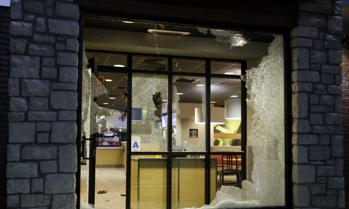 A store is vandalized after the announcement of the grand jury decision Monday, Nov. 24, 2014, in Ferguson, Mo. A grand jury has decided not to indict Ferguson police officer Darren Wilson in the death of Michael Brown, the unarmed, black 18-year-old whose fatal shooting sparked sometimes violent protests. (AP Photo/Jeff Roberson)
