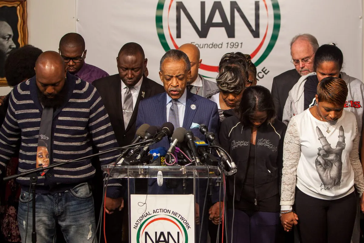Rev. Al Sharpton leads a prayer with the family members of Michael Brown, Eric Garner, and Akai Gurley, black men who died during encounters with police, in Harlem, on Nov. 26, 2014. (Petr Svab/Epoch Times)