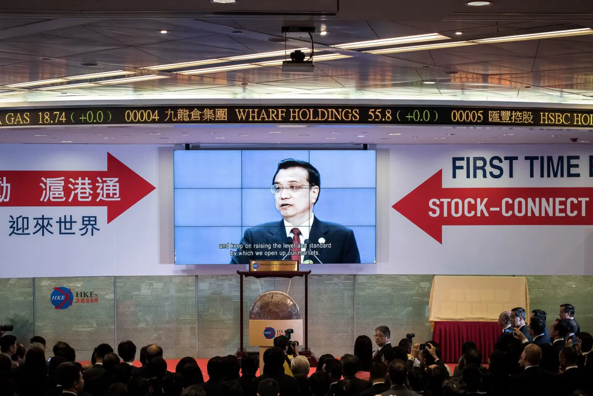 Guests watch a recorded video of China's Premier Li Keqiang (top C) during the launch of the Shanghai-Hong Kong Stock Connect in Hong Kong on Nov. 17, 2014. Officials had threatened that the opening of the new exchange would be delayed by the Umbrella Movement, which legislator Sin Chung-kai was part of an attempt to threaten Hong Kong into abandoning the movement. (Philippe Lopez/AFP/Getty Images)