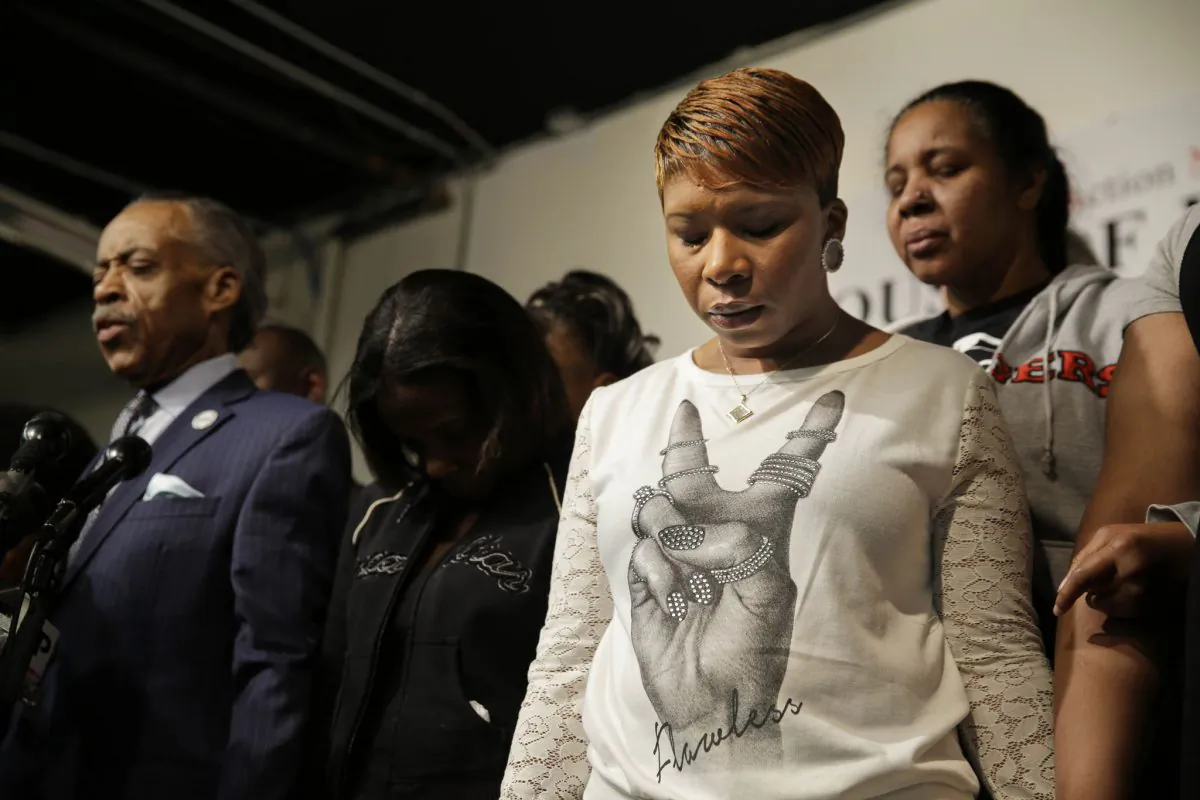 Lesley McSpadden (2R), mother of Michael Brown, prays with other families and Al Sharpton (L), at the National Action Network headquarters in New York, Wednesday, Nov. 26, 2014. On the day before Thanksgiving, Sharpton brought together the families of Michael Brown, Eric Garner and Akai Gurley, all black men recently killed by police officers. (AP Photo/Seth Wenig)