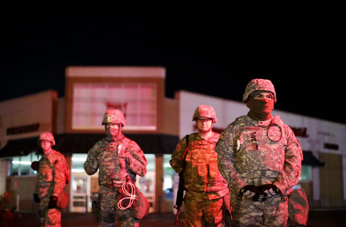 Missouri National Guard stand watch outside a Walgreens store, Wednesday, Nov. 26, 2014, in Ferguson, Mo. Missouri's governor ordered hundreds more state militia into Ferguson on Tuesday, after a night of protests and rioting over a grand jury's decision not to indict police officer Darren Wilson in the fatal shooting of Michael Brown, a case that has inflamed racial tensions in the U.S. (AP Photo/David Goldman)