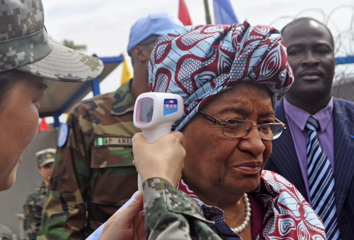 Liberian President Ellen Johnson Sirleaf (C) temperature is taken by a Chinese soldier (L) before the opening of a new Ebola virus clinic in Monrovia, Liberia, Tuesday, Nov. 25, 2014. Liberia got another 100 treatment beds in the fight against Ebola on Tuesday, as yet another Sierra Leonean doctor became infected with the disease sweeping West Africa. Liberian President Ellen Johnson Sirleaf toured the Ebola treatment center built by China, calling it first-class. (AP Photo/Abbas Dulleh)