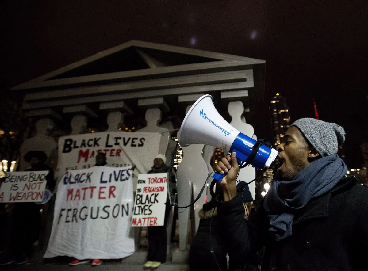 Thousands gather outside the U.S. Consulate in Toronto on Nov. 25, 2014, to protest a U.S. grand jury's decision not to indict a police officer who shot and killed Michael Brown of Feguson, Missouri. (The Canadian Press/Nathan Denette)