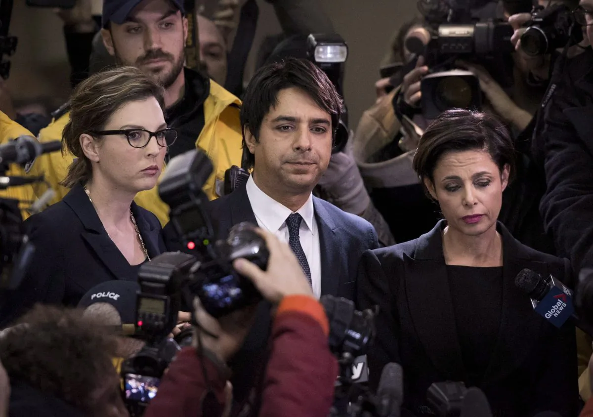 Jian Ghomeshi makes his way through a throng of media with his lawyer, Marie Henein (R), at a Toronto court on Nov. 26, 2014. Henein says the former CBC radio host plans to plead not guilty to multiple counts of sexual assault. (The Canadian Press/Darren Calabrese)