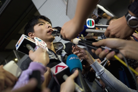 Student leader Joshua Wong (L) speaks to reporters outside a courthouse after he was released on bail in Hong Kong on November 27, 2014. A court in the semi-autonomous city banned the pro-democracy leader from entering a busy urban district one day after he was arrested from a major protest site when police moved in to clear out protesters. (Aaron Tam/AFP/Getty Images)